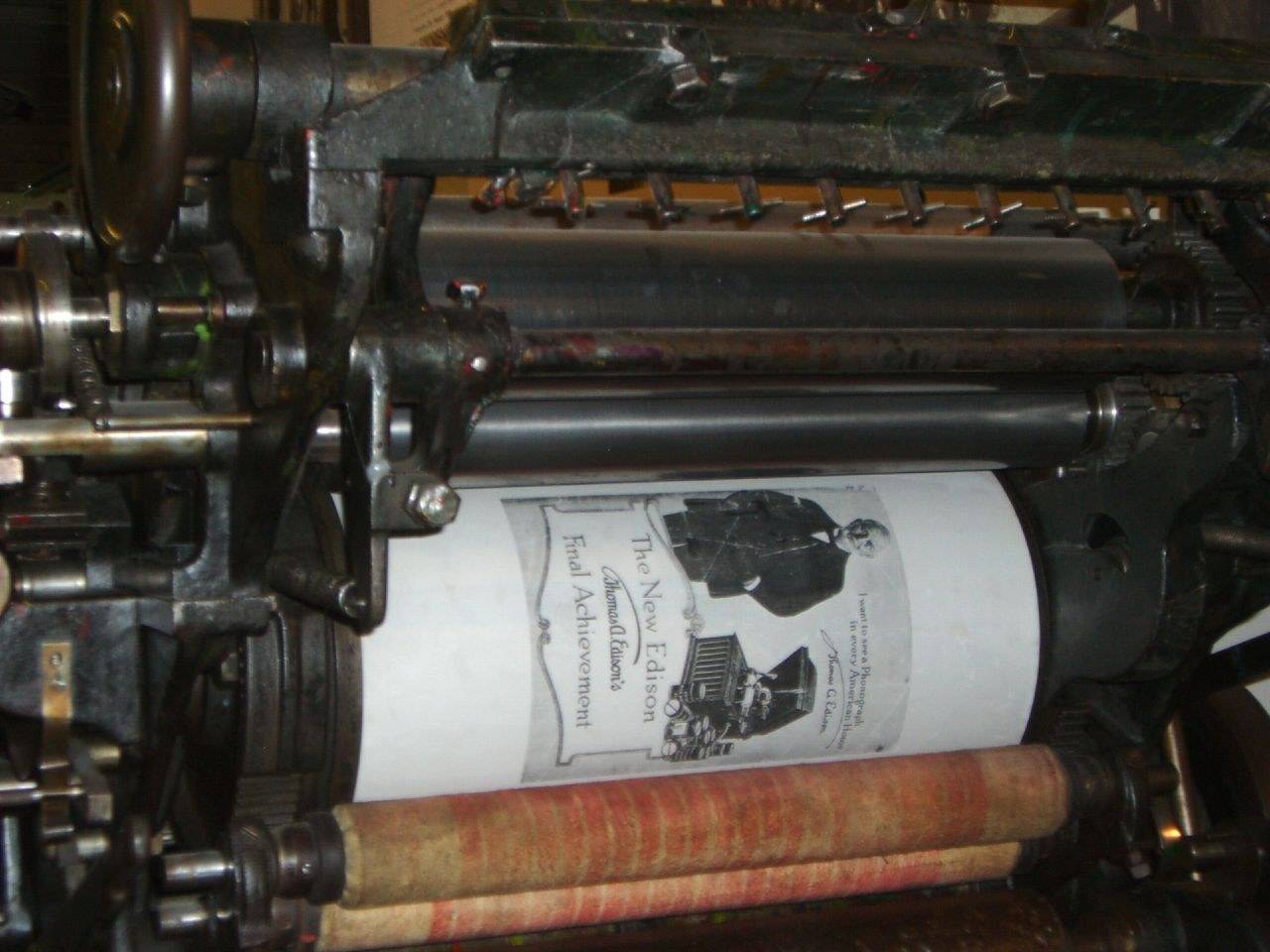 Cylindre d’une presse d’imprimerie ancienne avec une feuille imprimée en cours de tirage